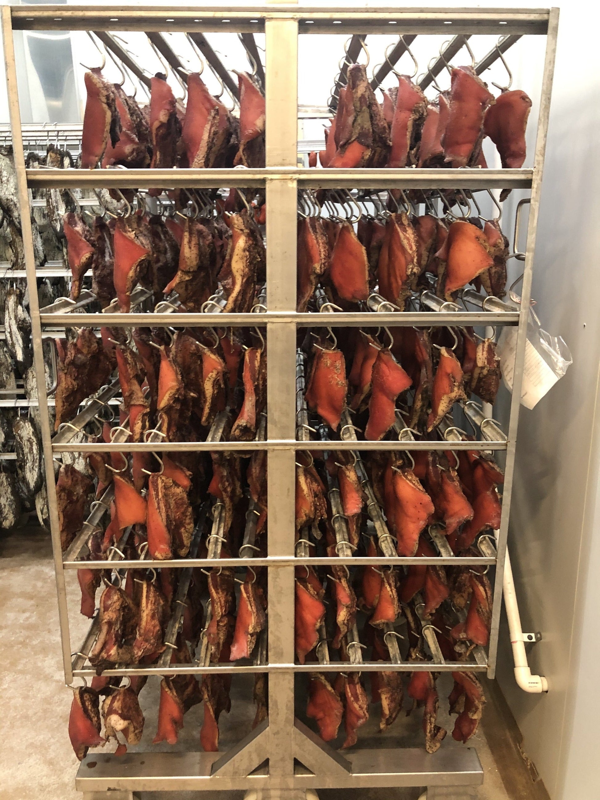 A trolley of Papandrea Guanciale air drying in the maturation room.